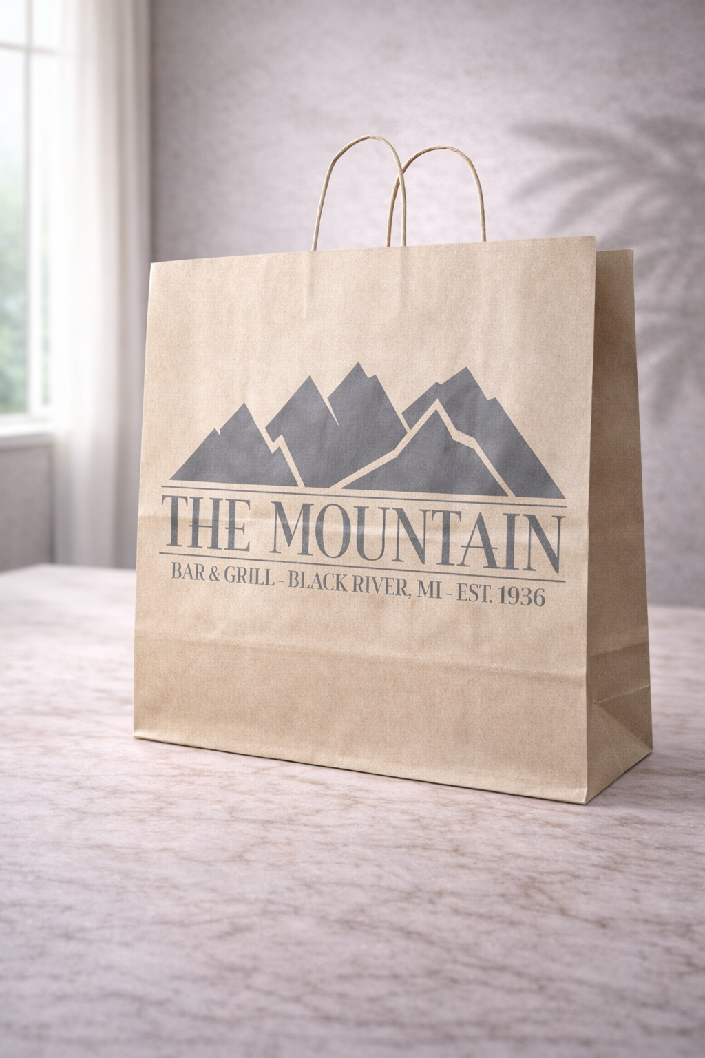 Extra-large kraft twisted handle paper bag with The Mountain Bar and Grill branding