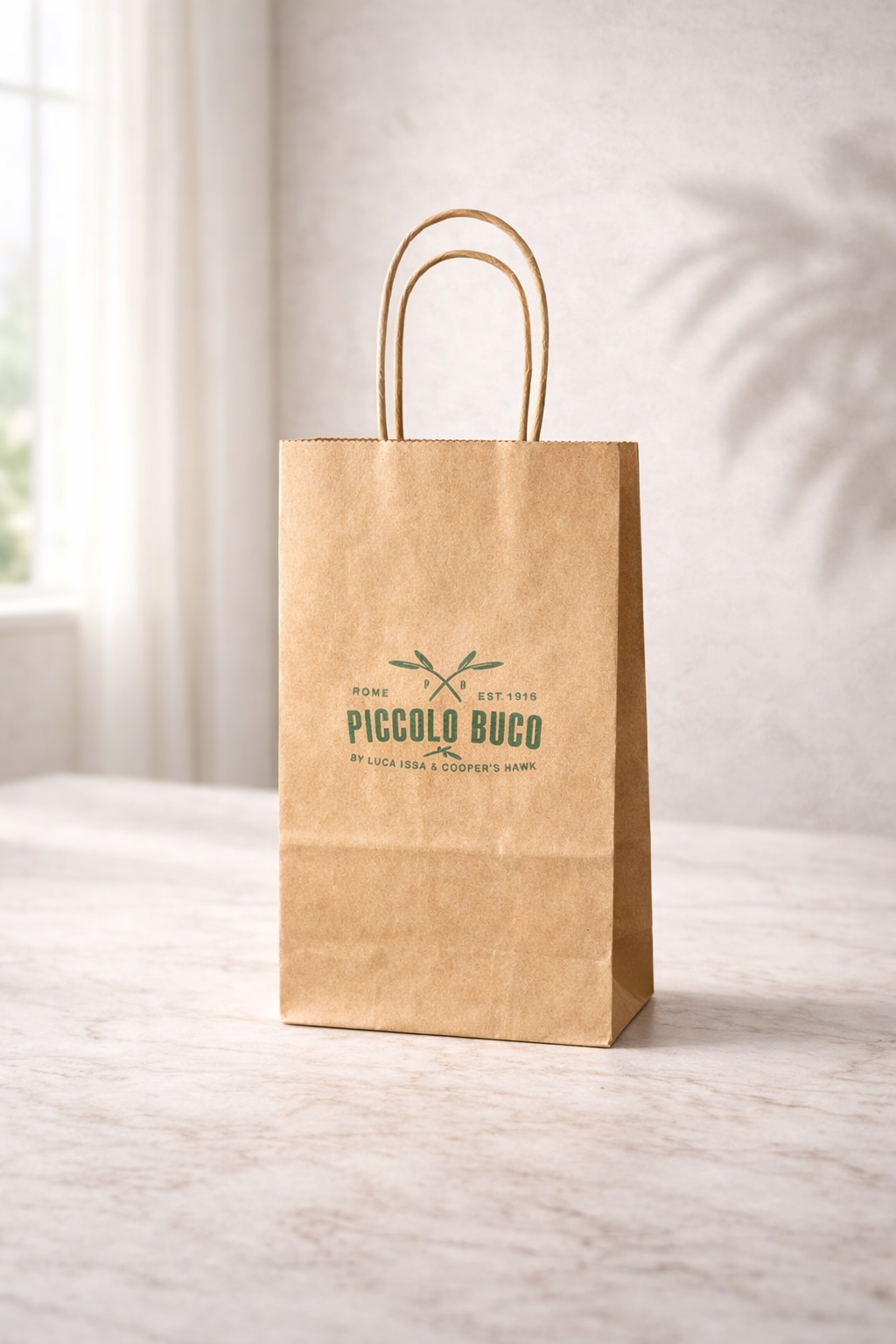 Small kraft twisted handle paper bag with Piccolo Buco branding