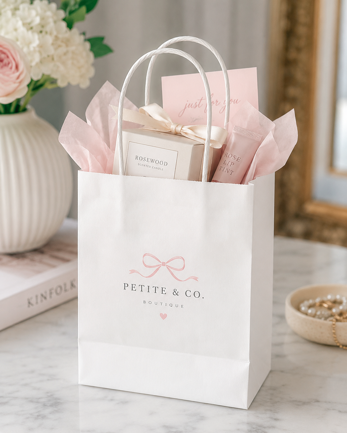Small white twisted handle paper bag holding skincare samples